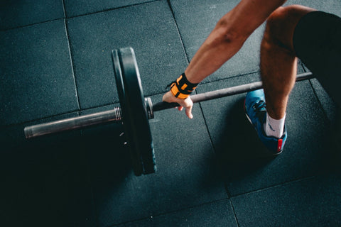 Adult lifting a barbell in a gym