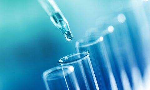 Laboratory pipette dropping liquid into test tubes