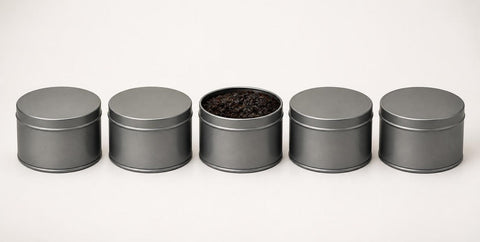 Row of plain unlabelled tins with one open showing shisha tobacco
