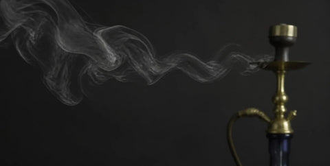 Wisp of smoke drifting from a shisha pipe on a dark background