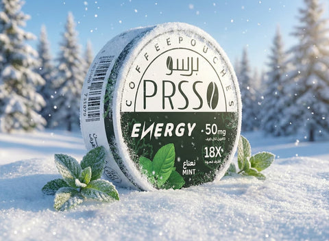 A round tin of PRSO COFFEEPOUCHES Energy mint coffee pouches sits in deep snow with frosted mint leaves around it and a blurred winter forest background.